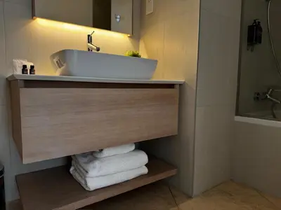 a bathroom with a sink and towels on a shelf at SkyHigh Park View Residence in Nicosia