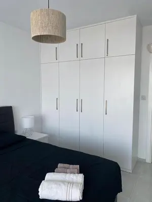 a bedroom with white cabinets and two towels on a bed at Northern Cyprus Iskele Bogaz Abelia One plus One Sea View in Boğaz