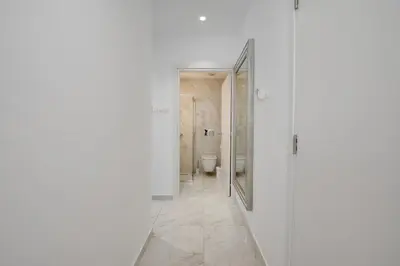 a bathroom with a toilet and a walk in shower at Oniro Suites Makenzy in Larnaka