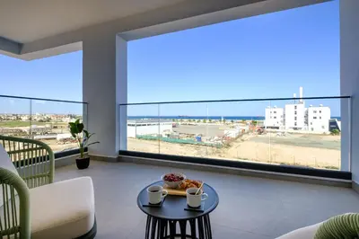 a living room with a table and a view of the beach at Artemis 206 - Seaside Stories in Livadhia