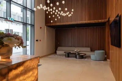 a lobby with a waiting room with a couch and a chandelier at SkyHigh Park View Living in Nicosia