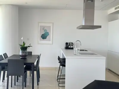 a kitchen and dining room with white walls and a table at SkyHigh Park View Living in Nicosia