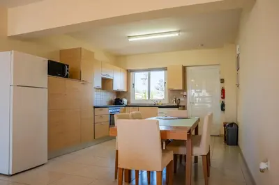 a kitchen with a table and a white refrigerator at Golden Sands No10 in Ayia Napa