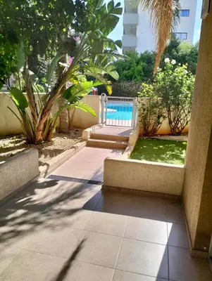 a patio with a swimming pool and a garden at Regina by the Sea in Limassol