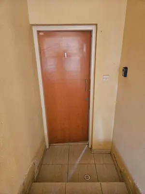 a wooden door in a hallway with a tile floor at ισόγειο διαμέρισμα με αυλή στην περιοχή Κάππαρη κατάλληλο για οικογενεια in Paralimni