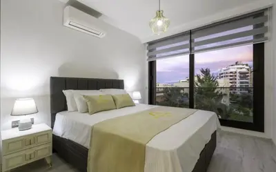 a bedroom with a large bed and a large window at Avrasya city in Ayios Dhometios