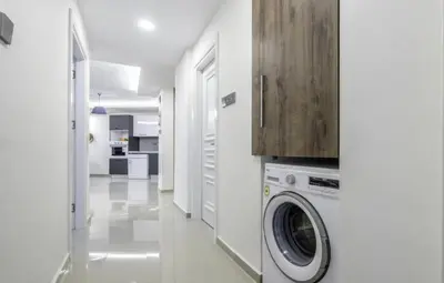 a white laundry room with a washer and dryer at Avrasya city in Ayios Dhometios