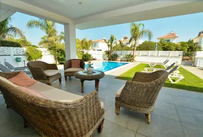 a patio with chairs and a table and a pool at Villa Emilia in Ayia Napa