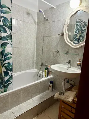 a bathroom with a tub and a sink and a mirror at Alison rooms in center in Larnaka