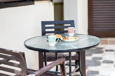 a table with two cups of coffee and a plate of food at Casa Piedra, Hidden Gem, Jacuzzi, BBQ, Patio in Monagroulli in Monagrulli