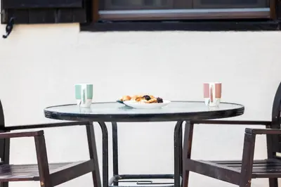 a table with a plate of food and two chairs at Casa Piedra, Hidden Gem, Jacuzzi, BBQ, Patio in Monagroulli in Monagrulli