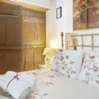 a bedroom with a white bed with flowers on it at Lefkara View in Pano Lefkara