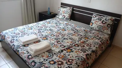 a bedroom with a large bed with a floral comforter at Unique City room in Larnaka
