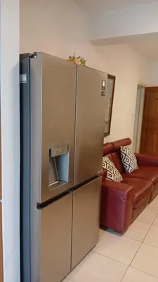 a stainless steel refrigerator in a living room with a couch at Unique City room in Larnaka