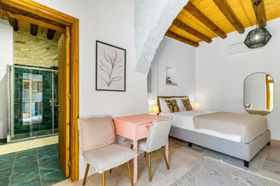 a bedroom with a bed and a table and chairs at Kallistheni - Stylish Studio Apartments in Lefkara in Pano Lefkara