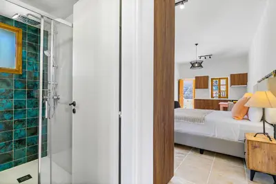 a bedroom with a bed and a glass shower at Kallistheni - Stylish Studio Apartments in Lefkara in Pano Lefkara