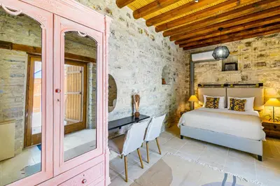 a bedroom with a bed and a desk in a room at Kallistheni - Stylish Studio Apartments in Lefkara in Pano Lefkara