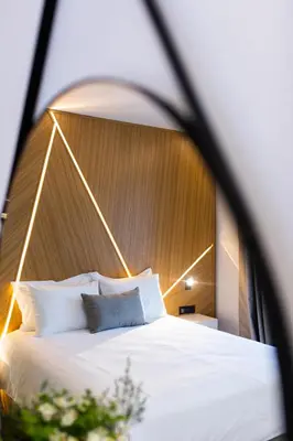 a bedroom with a large white bed with a wooden headboard at Old Port Hotel in Limassol