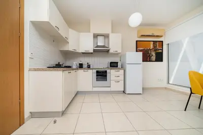 a kitchen with white appliances and a yellow chair at Modern 1 bedroom flat in Strovolos