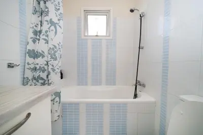 a bathroom with a tub and a toilet and a window at Modern 1 bedroom flat in Strovolos