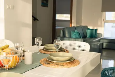 a table with two plates and wine glasses on it at Dahlia Napa Villa in Ayia Napa