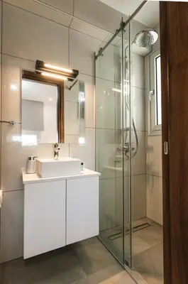 a bathroom with a sink and a glass shower at Dahlia Napa Villa in Ayia Napa