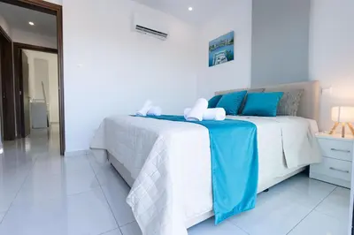 a bedroom with a bed with blue and white sheets at Dahlia Napa Villa in Ayia Napa