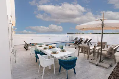 a patio with a table and chairs and an umbrella at Dahlia Napa Villa in Ayia Napa