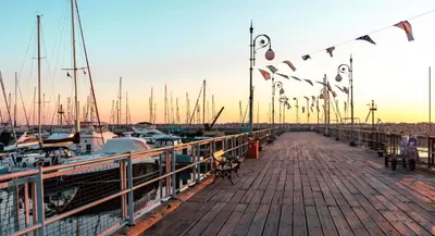 a wooden dock with boats and flags on it at Domus ArsEleAndra Studio-162 in Larnaka