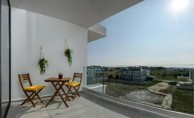 a dining room with a table and chairs and a large window at Sunny 1-Bedroom Apartment - StaysbyDais in Larnaka