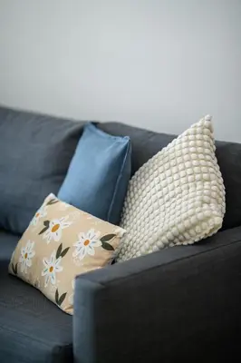 a black couch with three pillows on it at Sunny 1-Bedroom Apartment - StaysbyDais in Larnaka