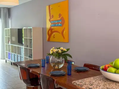 a dining room table with a vase of flowers on it at Zima Cove Calm Coastal Oasis in Limassol