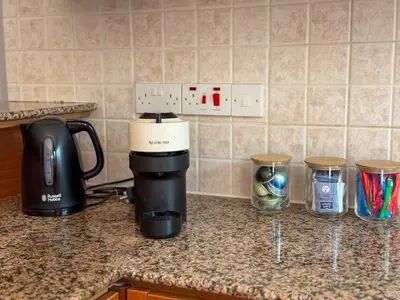 a kitchen counter with a coffee maker and containers on it at Zima Cove Calm Coastal Oasis in Limassol