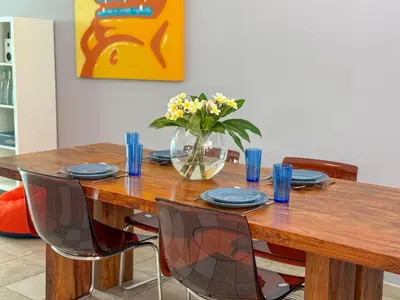 a wooden table with chairs and a vase of flowers at Zima Cove Calm Coastal Oasis in Limassol