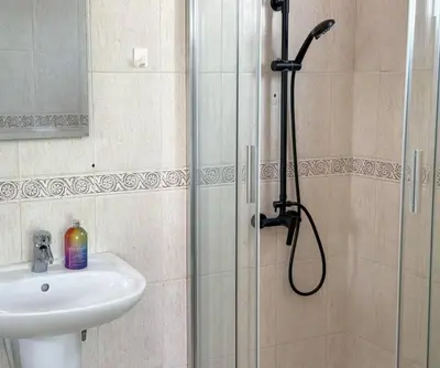 a shower with a glass door next to a sink at Zima Cove Calm Coastal Oasis in Limassol