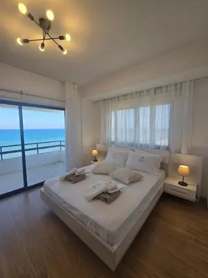 a bedroom with a large bed with a view of the ocean at Lazuli Skyline & Sea View Penthouse in Larnaka