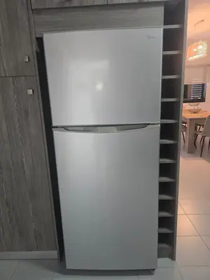 a white refrigerator in a kitchen next to a shelf at Lazuli Skyline & Sea View Penthouse in Larnaka
