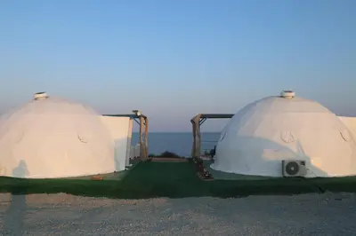 two domes on the beach with the ocean in the background at Domes at the Beach in Maroni