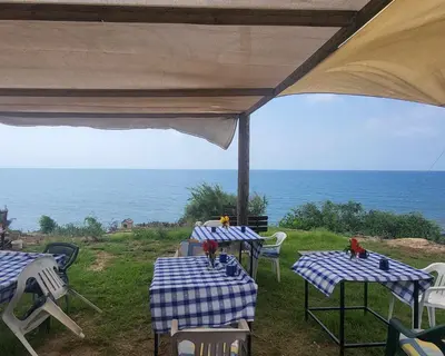 a group of tables and chairs with the ocean in the background at Domes at the Beach in Maroni