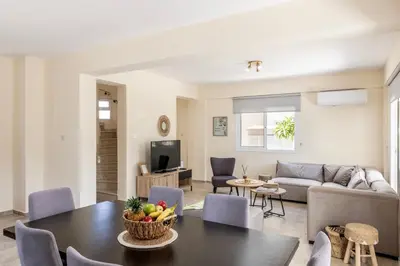 a living room with a table and a couch at Villa Chrystalla in Paralimni