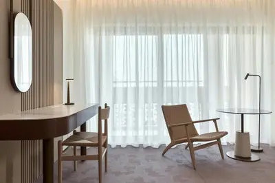 a room with a desk and chairs and a window at The Landmark Nicosia, Autograph Collection in Nicosia