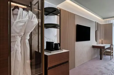 a hotel room with a closet with a tv at The Landmark Nicosia, Autograph Collection in Nicosia
