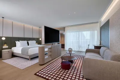 a hotel room with a bed and a couch at The Landmark Nicosia, Autograph Collection in Nicosia