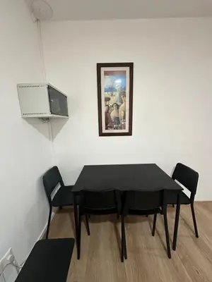 a black table and chairs in a room with a painting at Finikoudes Central Apartment in Larnaka