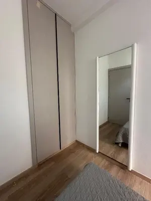 an empty room with a mirror and a bed at Finikoudes Central Apartment in Larnaka