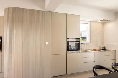 a kitchen with white cabinets and a window at Villa Mesogeios 4 in Protaras