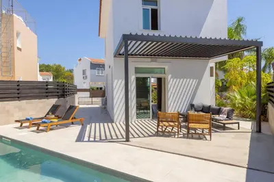 a house with a swimming pool and a patio at Villa Mesogeios 4 in Protaras