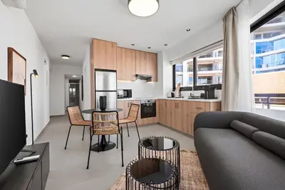 a kitchen and living room with a couch and a table at Finikoudes Marina View #201 in Larnaka
