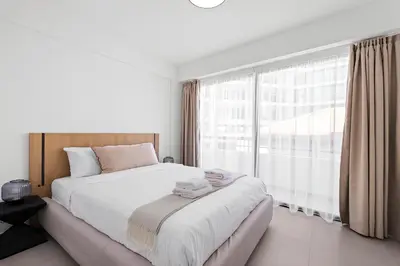 a bedroom with a large bed and a large window at Finikoudes Marina View #201 in Larnaka