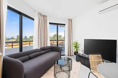 a living room with a couch and a tv at Finikoudes Marina View #201 in Larnaka